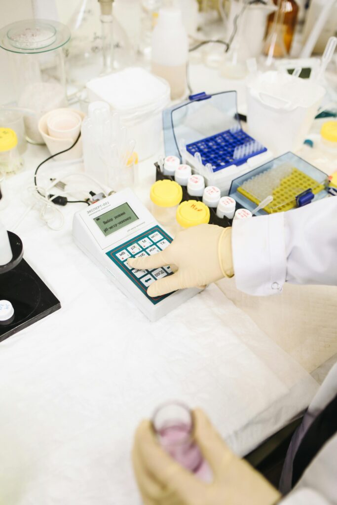 Scientist interacts with a device amidst laboratory equipment for research purposes.